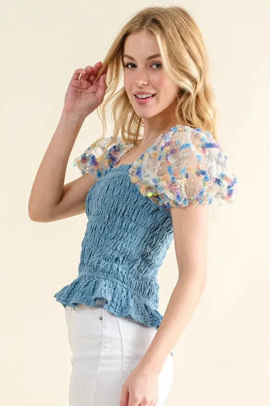 Blue Smocked Top with Multicolor Floral Puff Sleeves – Ruffled Hem Detail