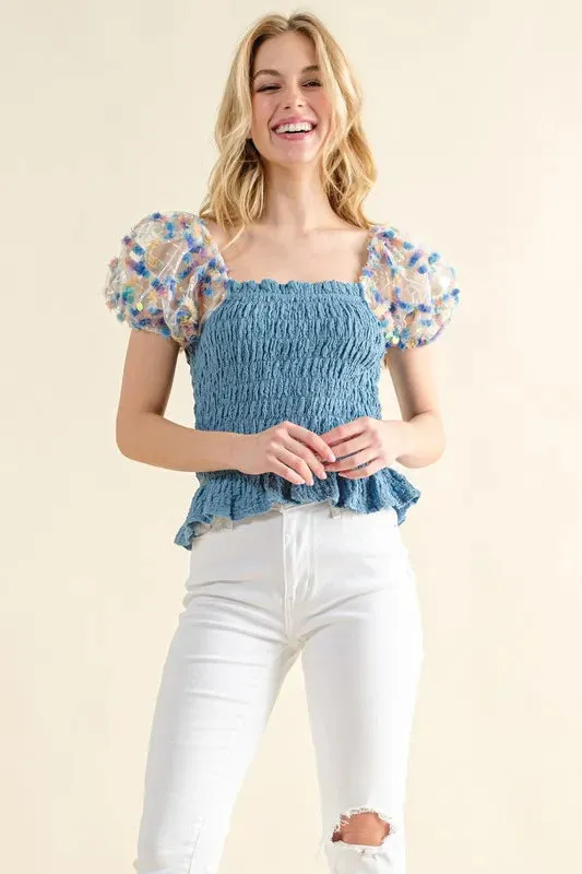 Blue Smocked Top with Multicolor Floral Puff Sleeves – Ruffled Hem Detail